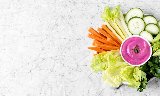 Vue de dessus des légumes et de la sauce rose sur une plaque avec copie espace