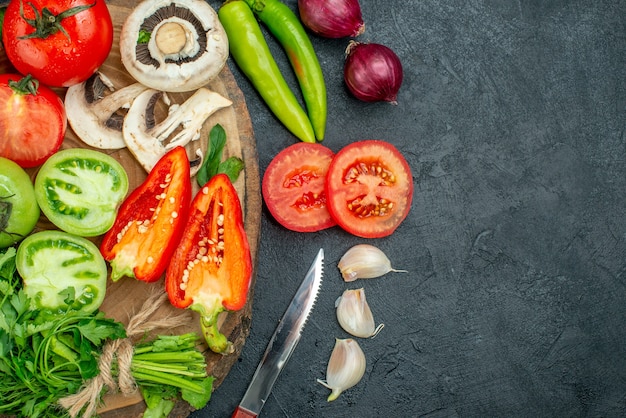 Vue de dessus légumes tomates poivrons concombres verts champignons sur planche de bois