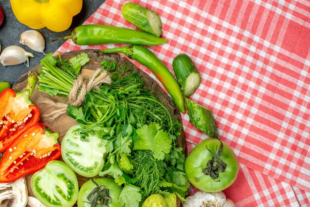 Vue de dessus légumes tomates poivrons rouges verts sur planche de bois