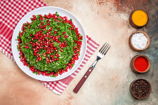 Vue de dessus des légumes verts frais avec des grenades pelées sur un repas de légumes verts aux fruits de la table lumineuse