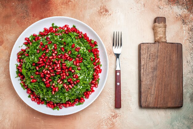 Vue de dessus des légumes verts frais avec des grenades pelées sur la table lumineuse repas couleur des fruits vert