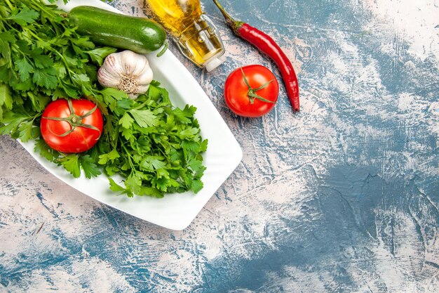 Vue de dessus des légumes verts frais avec des légumes sur fond bleu clair