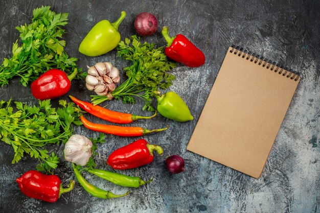 Vue de dessus des légumes verts frais avec des poivrons et de l'ail sur une table gris clair