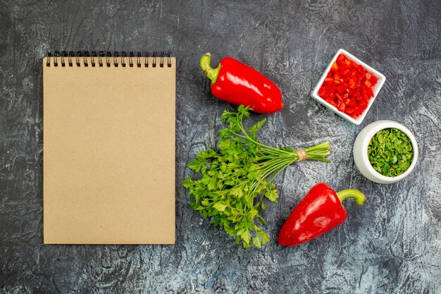 Vue de dessus des légumes verts frais avec des poivrons rouges sur la table gris clair