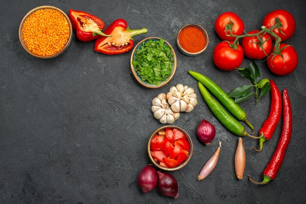 Vue de dessus des lentilles de légumes colorés dans un bol à côté des légumes colorés et des épices