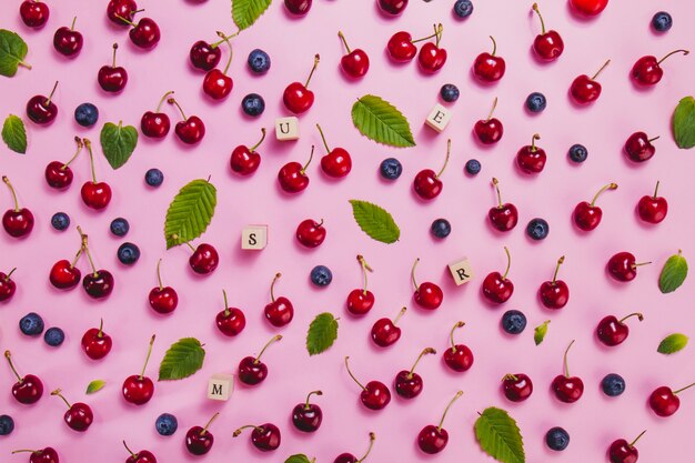 Vue de dessus des lettres et des fruits d&#39;été sur la surface rose