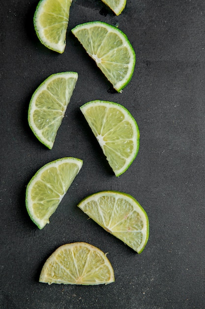 Vue De Dessus De Limes En Tranches Sur Une Surface Noire