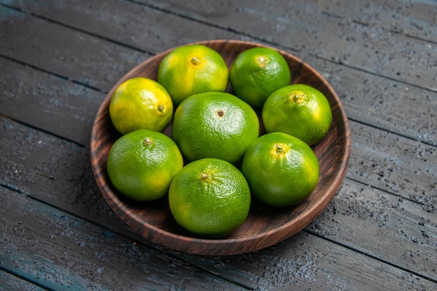 Vue de dessus limes vert-jaune limes vert-jaune en plaque brune sur la table