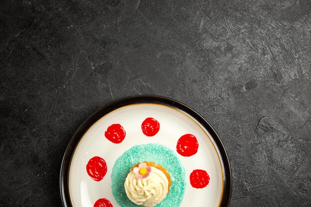 Vue de dessus de loin assiette d'assiette à dessert d'un dessert appétissant avec des sauces sur la table sombre