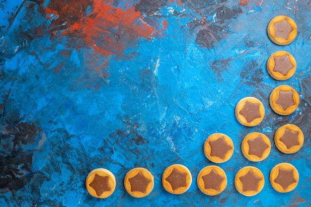 Vue de dessus de loin les biscuits au chocolat bonbons sur la table bleue