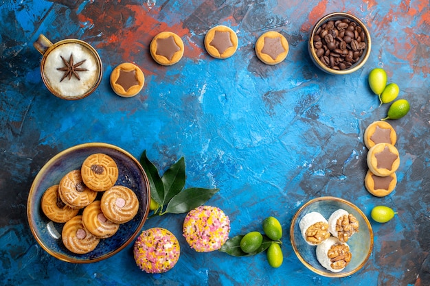 Vue de dessus de loin bonbons différents biscuits bonbons grains de café une tasse de café