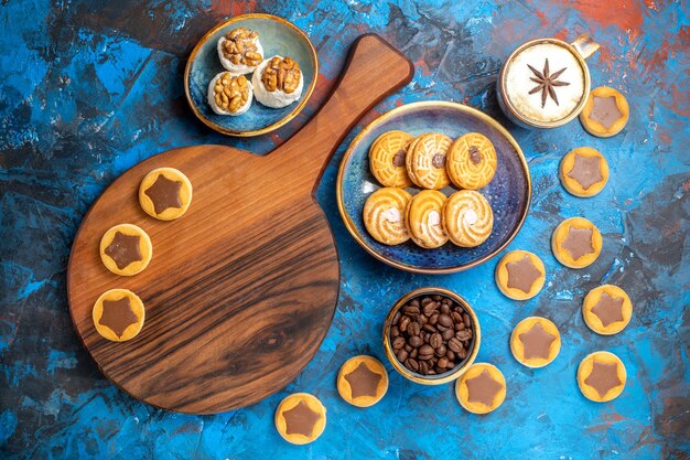 Vue de dessus de loin bonbons loukoums cookies sur le conseil des grains de café une tasse de café