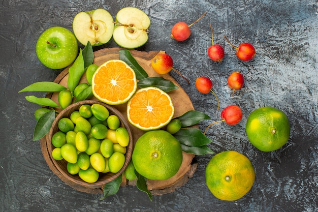 Vue de dessus de loin fruits cerises pommes agrumes sur la planche à découper