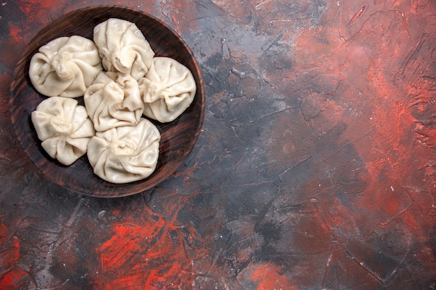 Vue de dessus de loin khinkali l'appétissant khinkali dans le bol sur la table rouge-gris