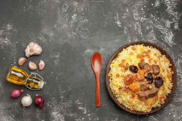 Vue de dessus de loin riz pilaf oignon ail bouteille de cuillère à huile