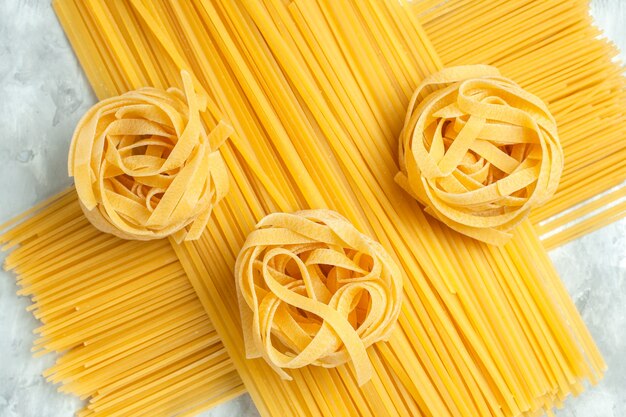 Vue de dessus de long produit cru de pâtes italiennes sur fond blanc