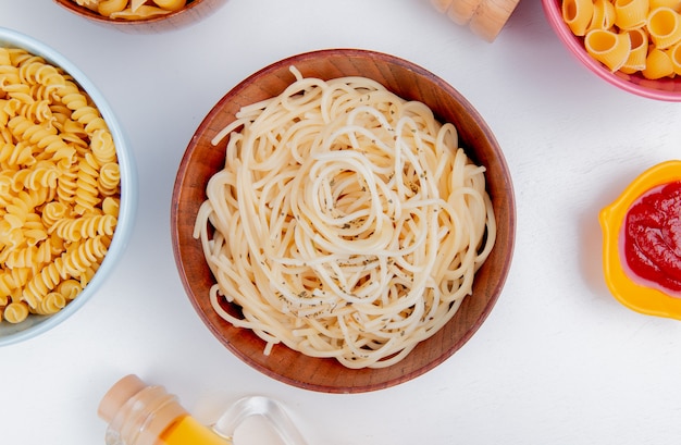 Photo gratuite vue de dessus des macaronis comme spaghetti rotini et pipe-rigate avec du ketchup sur blanc