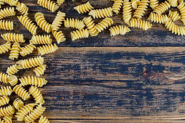 Vue de dessus des macaronis sur fond de bois foncé. espace horizontal pour le texte