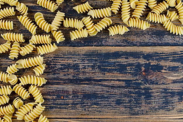 Vue de dessus des macaronis sur fond de bois foncé. espace horizontal pour le texte