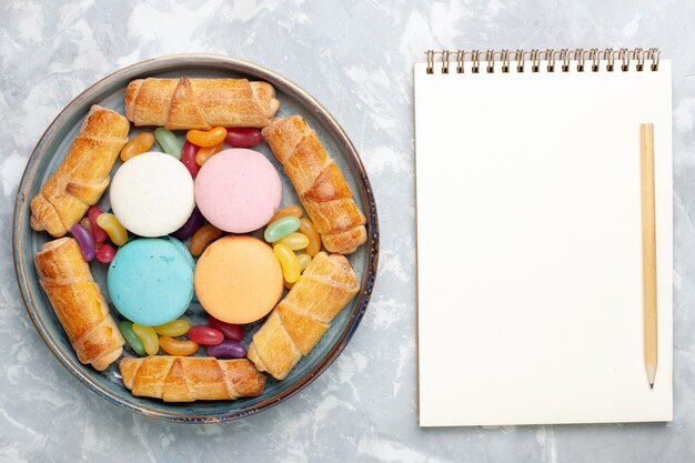 Vue de dessus macarons français avec bagels et bloc-notes sur blanc