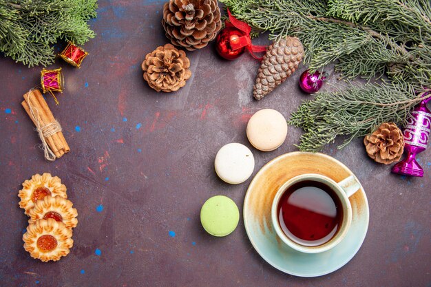 Vue de dessus des macarons français avec biscuits et thé sur fond noir