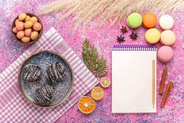 Vue de dessus macarons français avec des gâteaux au chocolat sur le rose