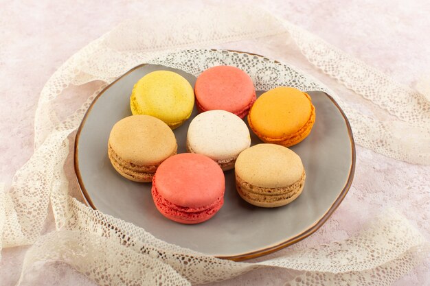 Une Vue De Dessus Macarons Français Rond Et Délicieux à L'intérieur De La Plaque Sur La Table Rose Gâteau Biscuit Sucre Sucré