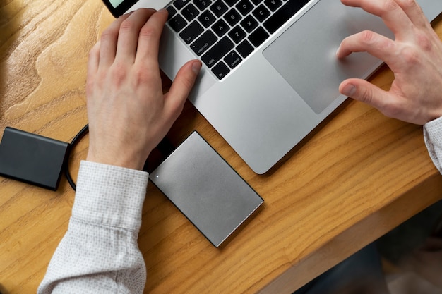 Vue De Dessus Des Mains à L'aide D'un Ordinateur Portable Au Bureau