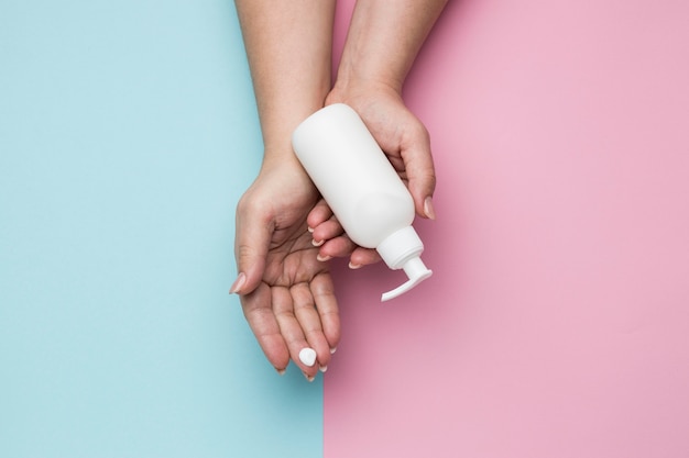 Vue de dessus des mains avec une bouteille de gel hydroalcoolique