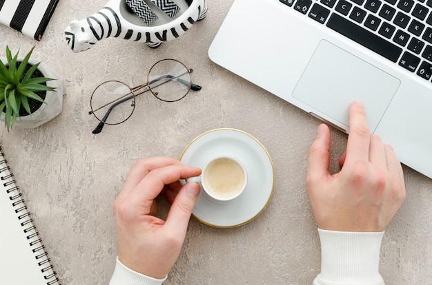 Vue de dessus des mains avec café et ordinateur portable