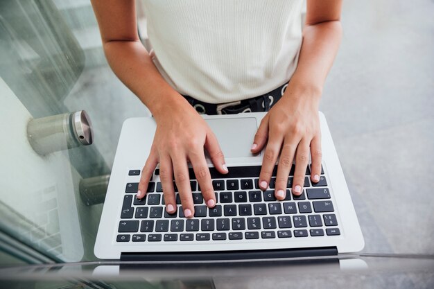 Vue de dessus des mains sur le clavier d'ordinateur portable