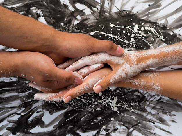 Vue de dessus des mains avec de la peinture blanche