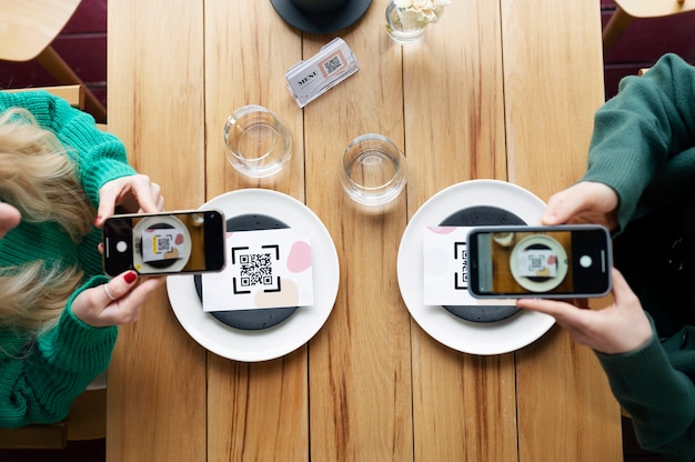 Photo gratuite vue de dessus des mains scannant les codes qr