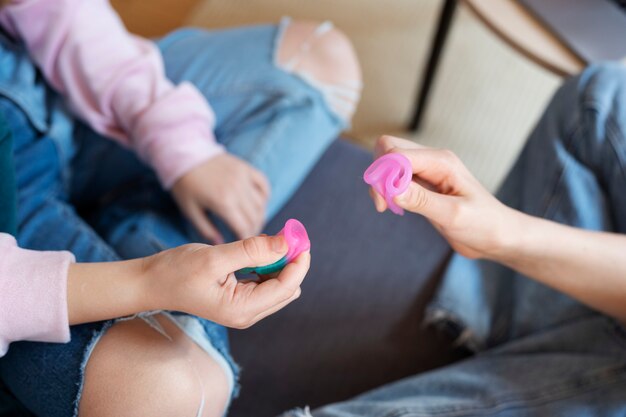 Vue de dessus des mains tenant des coupes menstruelles