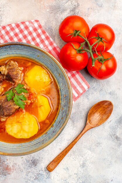 Vue de dessus maison soupe bozbash serviette de cuisine cuillère en bois tomates sur fond nu