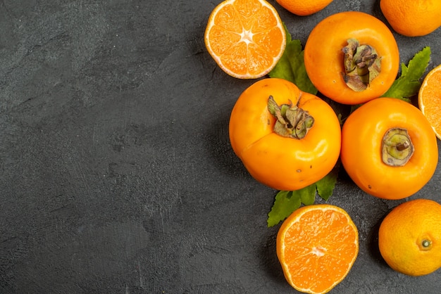 Vue de dessus des mandarines fraîches aux kakis sur fond gris