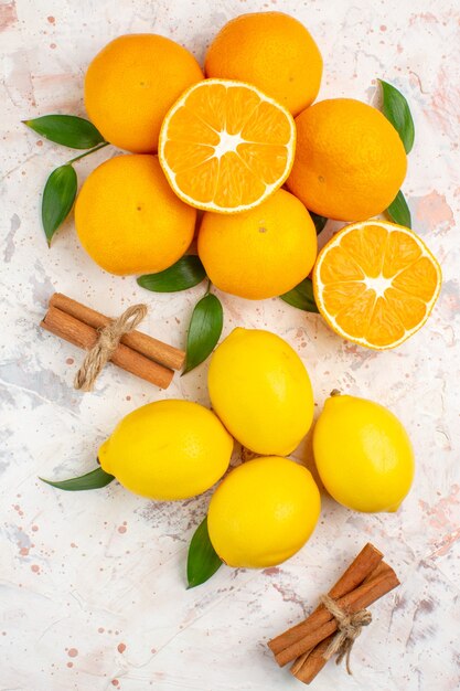 Vue de dessus mandarines fraîches citrons bâtons de cannelle sur une surface isolée lumineuse