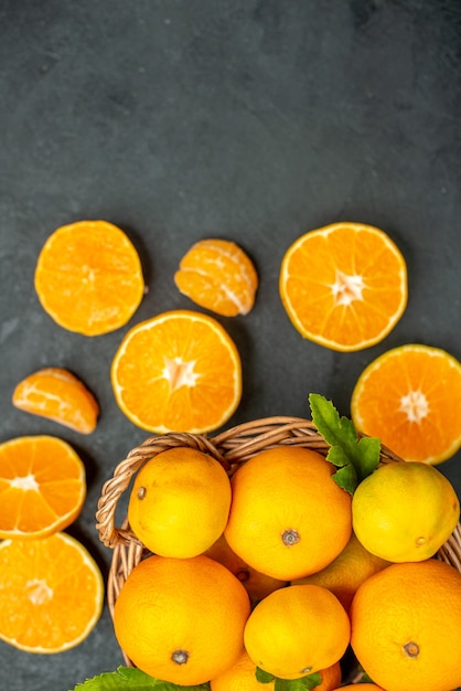 Photo gratuite vue de dessus des mandarines fraîches dans un panier en osier sur fond sombre