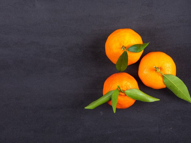 Vue de dessus de mandarines fraîches sur la surface noire