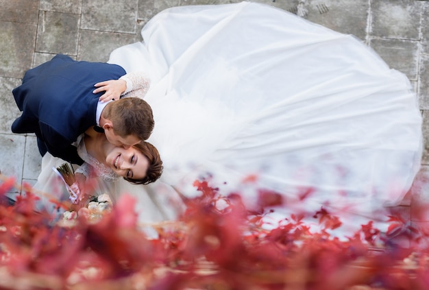 Photo gratuite vue de dessus de la mariée et du marié sourit s'embrasse sur la joue, mariage heureux