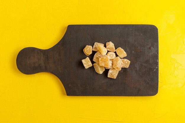 Vue de dessus de la marmelade en tranches sucrée et du sucre sur une surface jaune