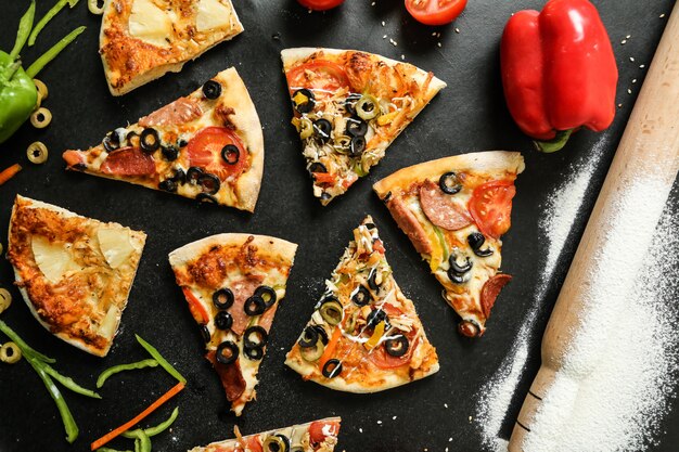 Vue de dessus mélange à pizza avec tomates olives et poivrons sur tableau noir