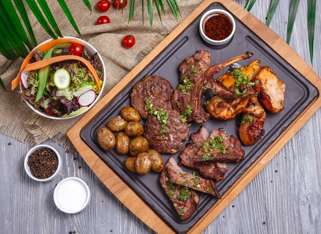 Vue de dessus mélange de steaks avec salade de légumes et sauce aux pommes de terre