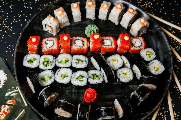 Vue de dessus mélanger des rouleaux de sushi sur une assiette avec du wasabi et du gingembre