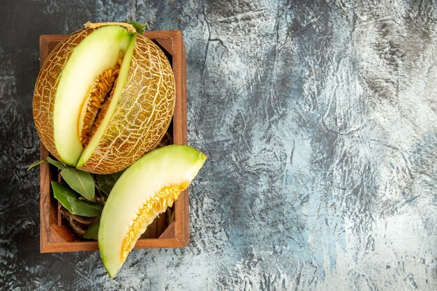 Vue de dessus de melon frais en tranches sur la table sombre-lumière douce fruits d'été doux