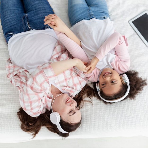 Photo gratuite vue de dessus, mère et fille, écouter de la musique