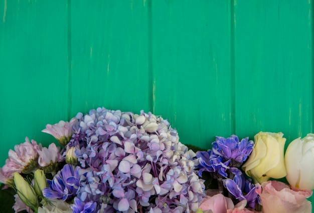 Vue de dessus de merveilleuses fleurs colorées comme gardenzia daisy rose sur un fond en bois vert avec espace copie