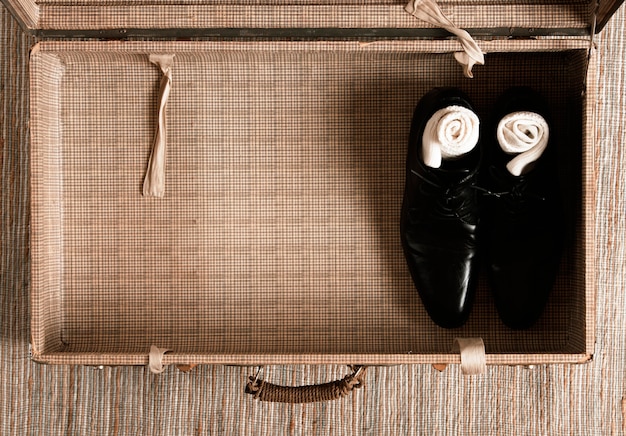 Vue de dessus à moitié vide valise vintage avec des vêtements décontractés