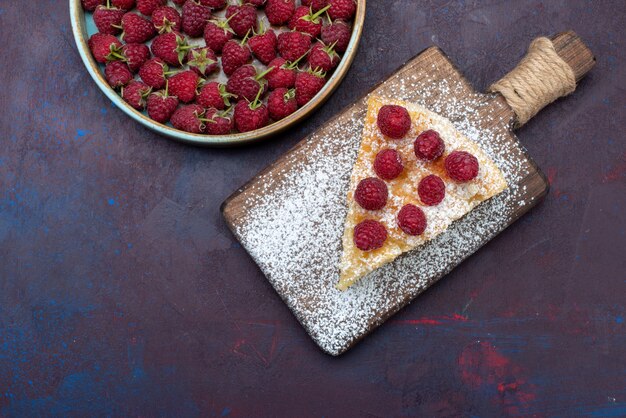 Vue de dessus morceau de gâteau cuit sucré avec des framboises sur le bureau sombre