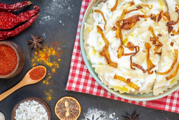 Vue de dessus des morceaux de pâte cuits avec des oignons frits et différents ingrédients sur le fond sombre dîner huile alimentaire repas cuisson plat photo